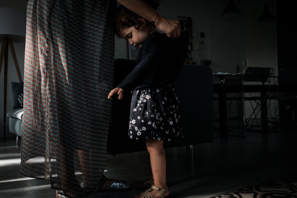 une maman aide sa fille à s'habiller photographe famille toulouse