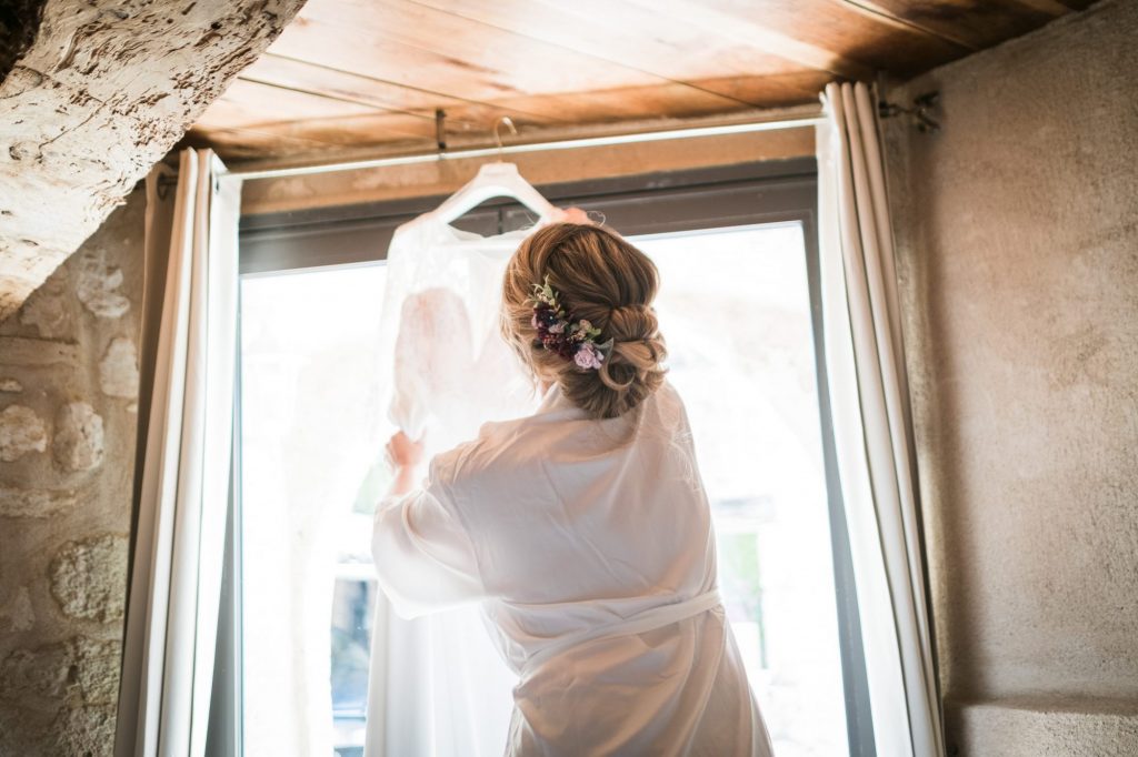 la mariée décroche sa robe de mariée dans l'annexe du chateau de mauriac