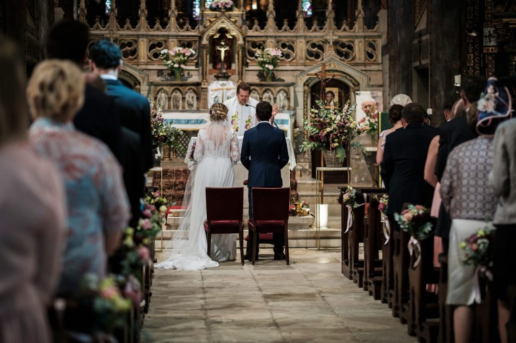 les mariés de dos devant l'autel de Notre Dame de la Drèche