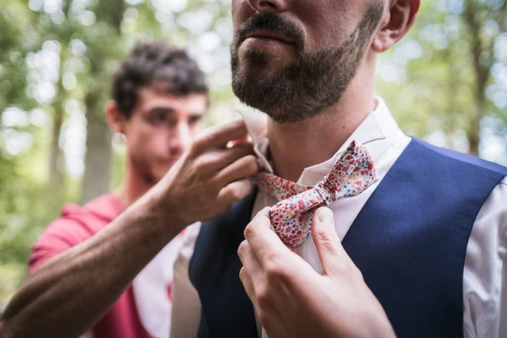 photographe mariage étangs de taysse le témoin aide le marié avec son noeud papillon fait main